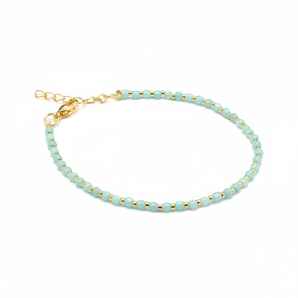 Pale aqua beaded bracelet with gold accents and ornate clasp professional product photo"