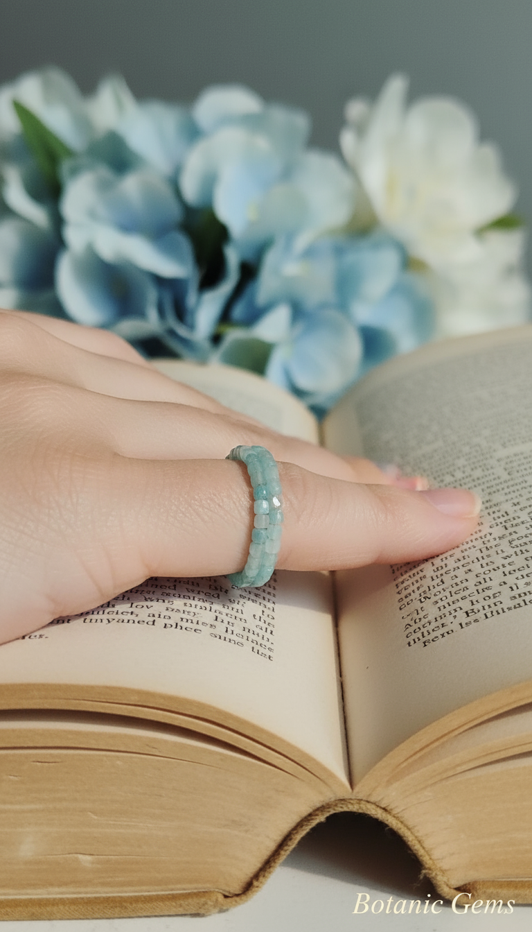 Aquamarine gemstone ring on vintage book with blue flowers