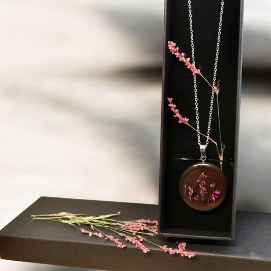 Close-up of delicate dried pink persicaria flower detail in handmade resin pendant from Botanic Gems Jewelry