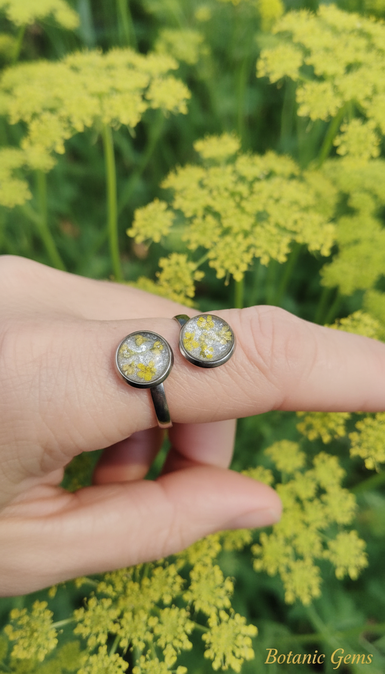 Double Pressed Flower Resin Ring on Hand with Yellow Queen Anne's Lace Background - Unique two-circle resin ring with pressed yellow and white flowers,