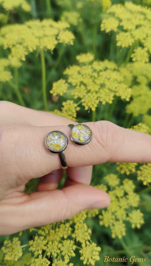 Double Pressed Flower Resin Ring on Hand with Yellow Queen Anne's Lace Background - Unique two-circle resin ring with pressed yellow and white flowers,