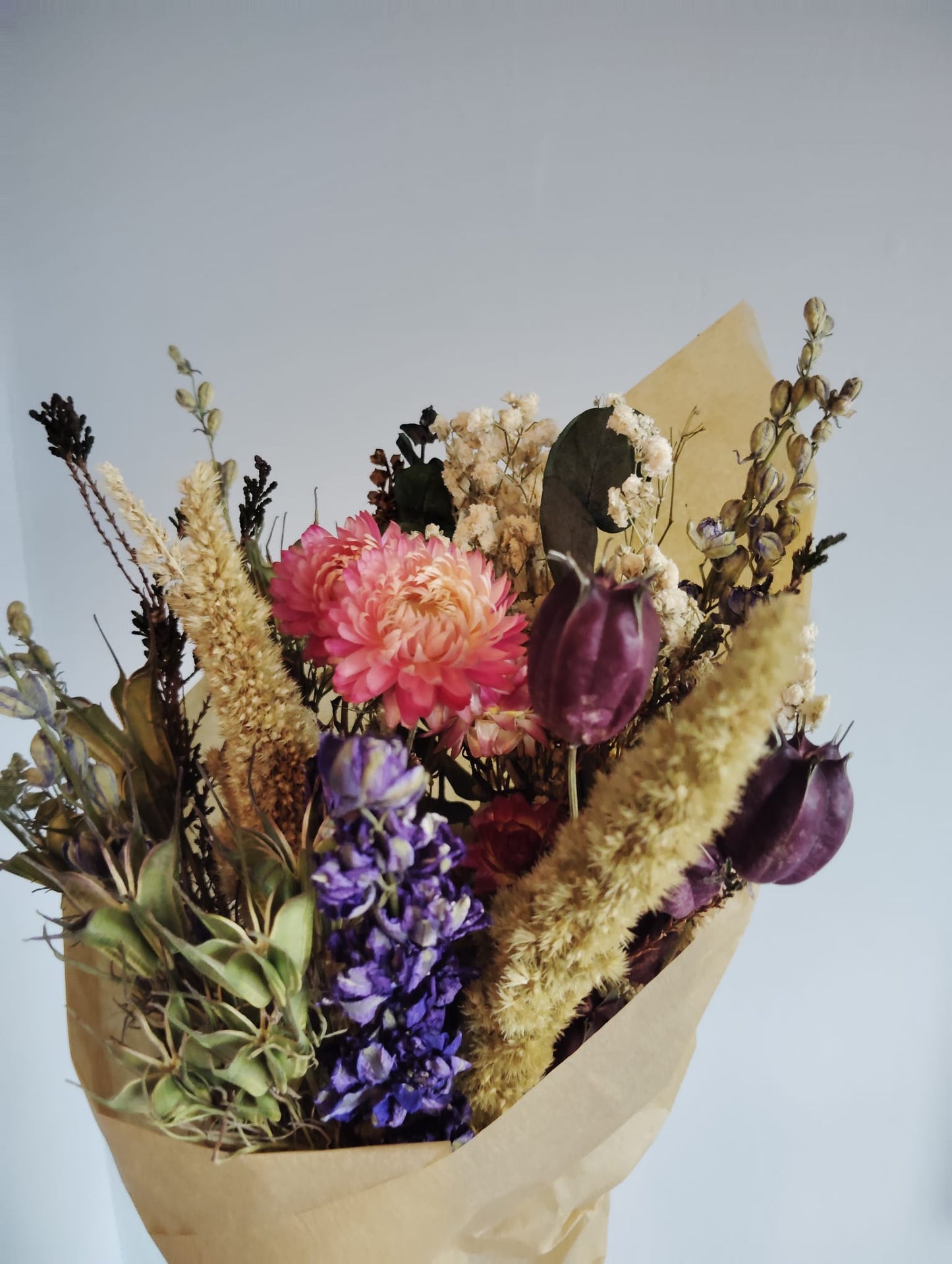 Detailed texture of an everlasting floral wreath handmade in Ireland using real preserved flowers in yellow, red, and green tones.