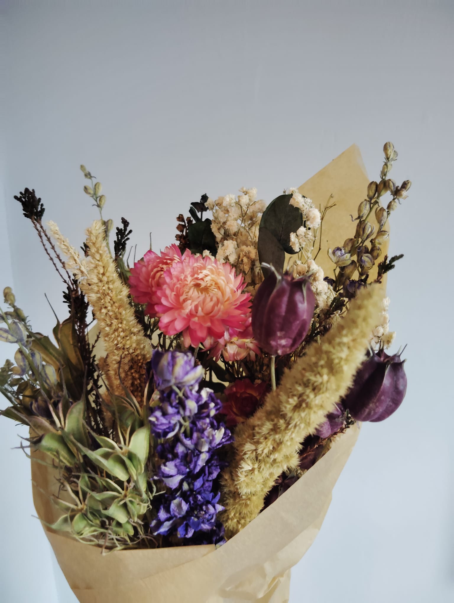 Detailed texture of an everlasting floral wreath handmade in Ireland using real preserved flowers in yellow, red, and green tones.
