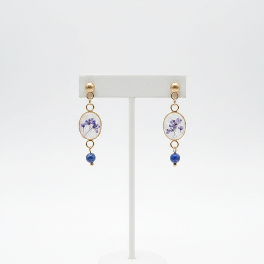 Violet lapis lazuli drop earrings on stand, white background