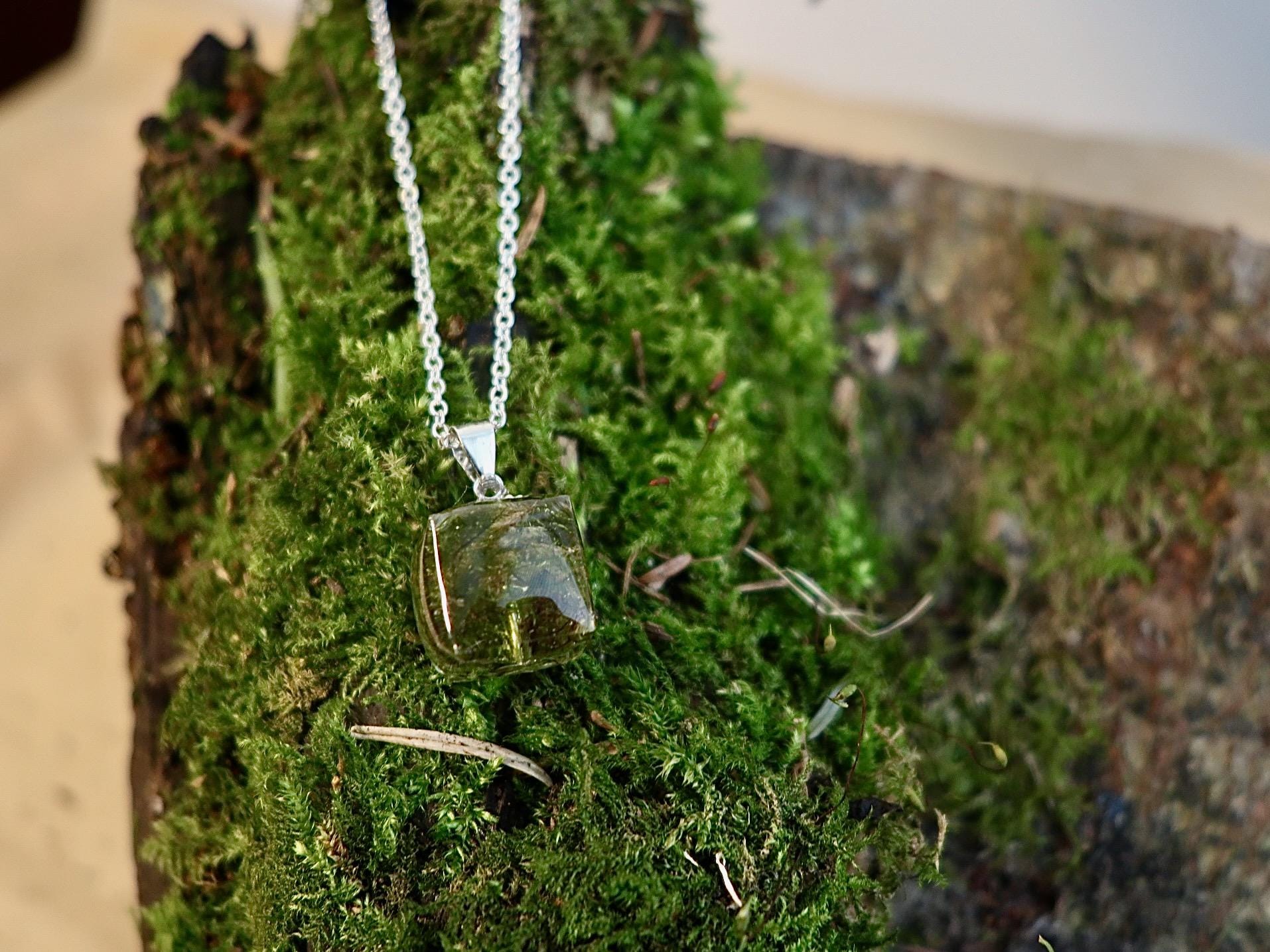 Real Irish moss pendant encased in clear resin, displayed on a clean background, from Botanic Gems Jewelry