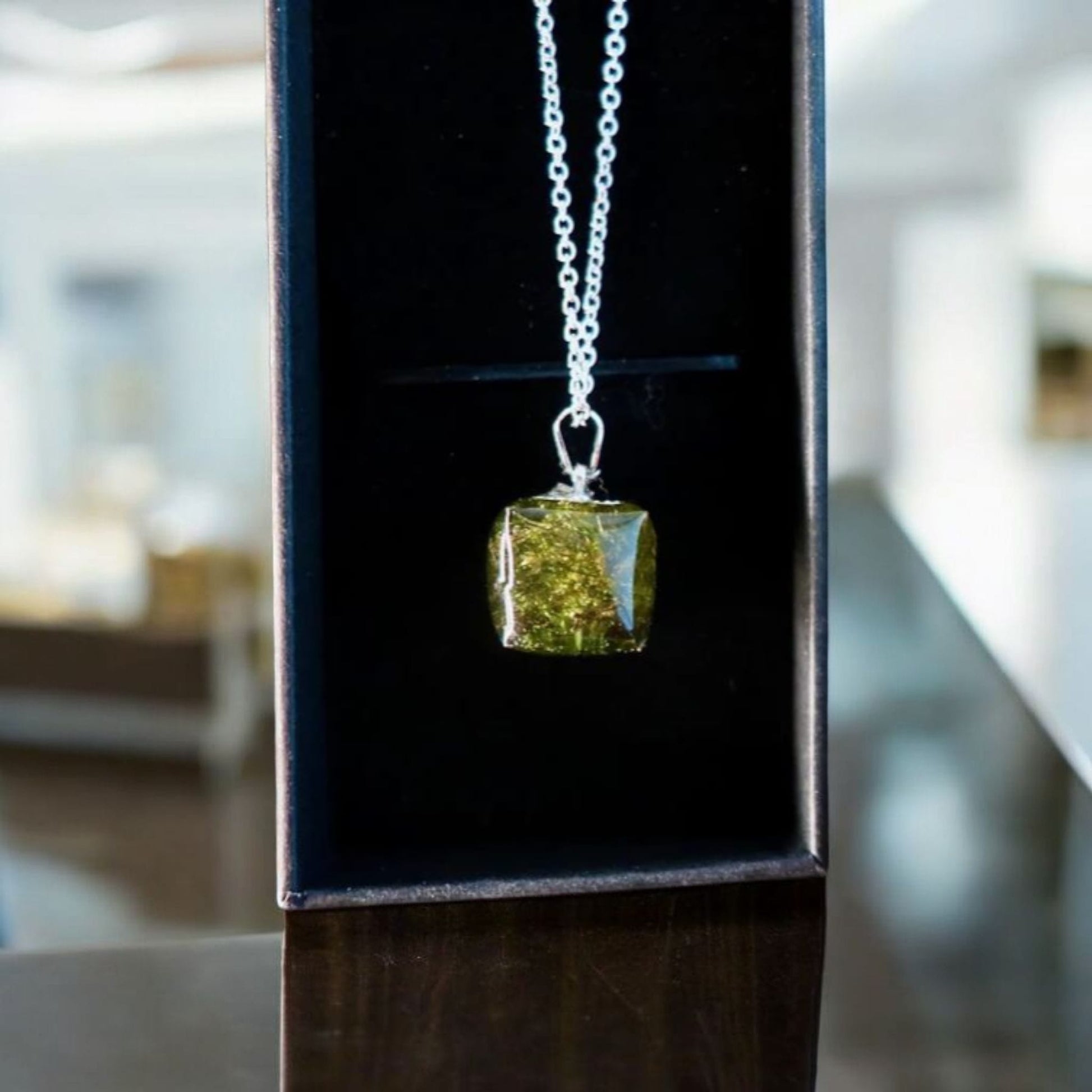 Real Irish moss pendant encased in clear resin, displayed on a clean background, from Botanic Gems Jewelry