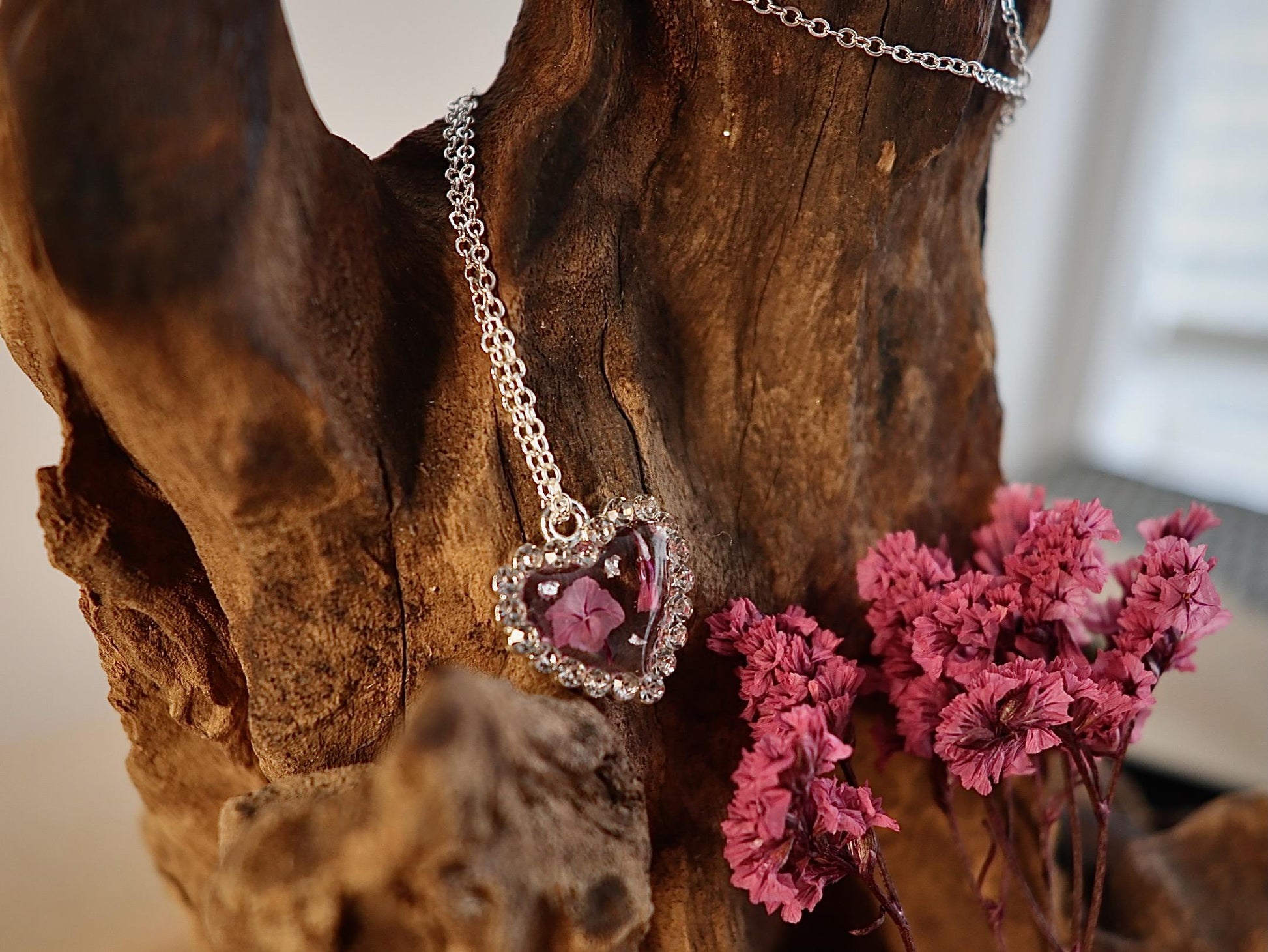 Close-up of delicate pink limonium flowers preserved in clear resin, handmade by Botanic Gems Jewelry