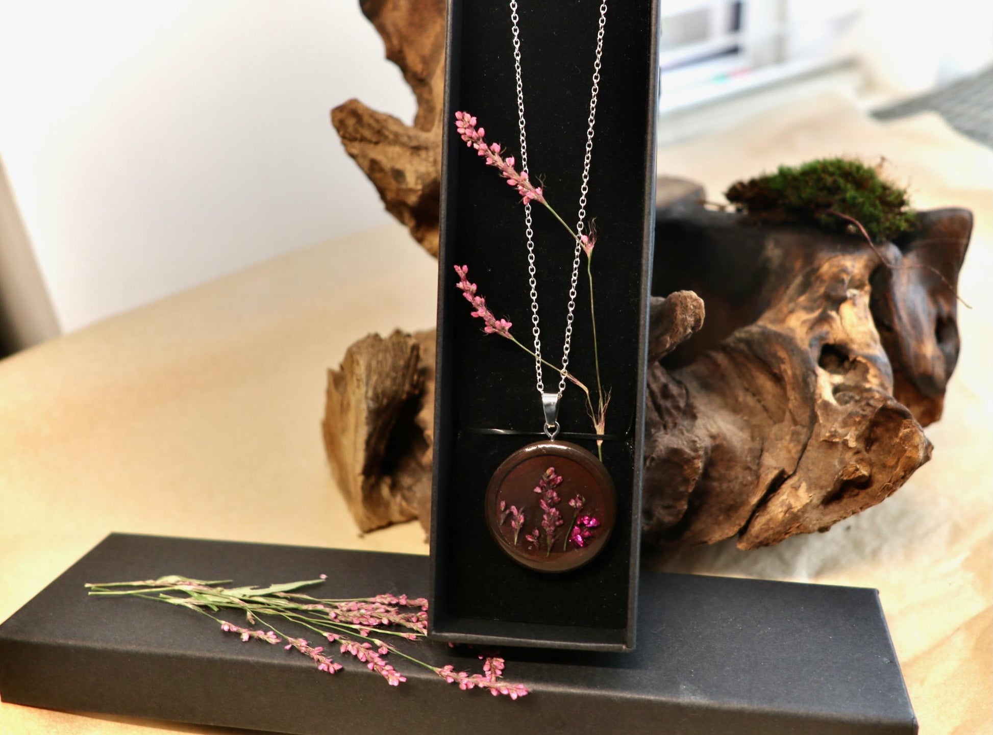 "Close-up of delicate dried pink persicaria flower detail in handmade resin pendant from Botanic Gems Jewelry