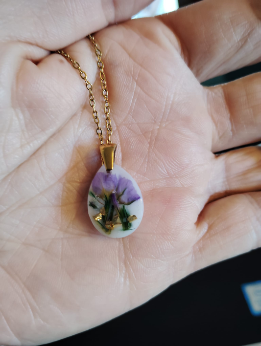 Purple limonium flower necklace with gold leaf detail in clear resin pendant on chain
