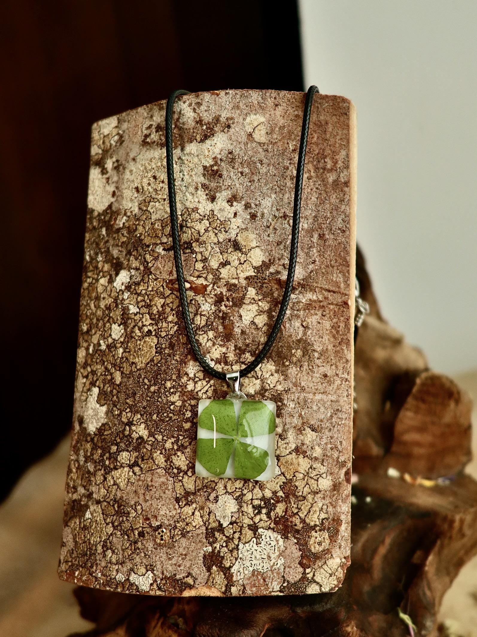 Close-up of a real four-leaf clover preserved in clear resin, showcasing the delicate details of the Irish botanical necklace