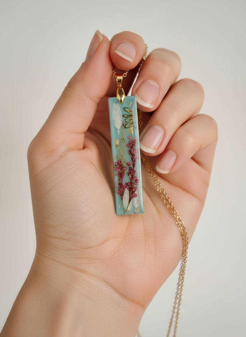 Turquoise blue heather flower resin pendant held in hand showing size and detail"