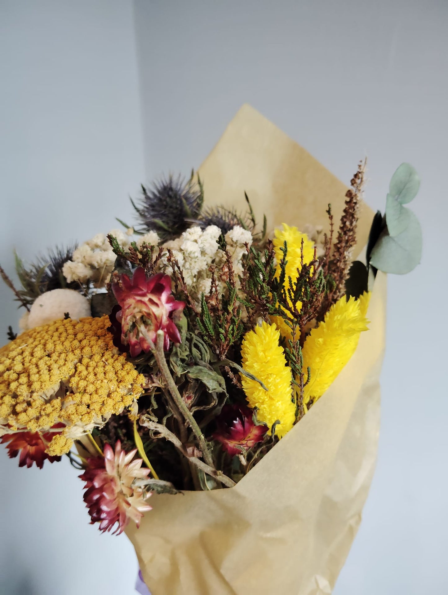 Irish wild meadow inspired dried floral arrangement with yellow everlastings and white baby's breath.