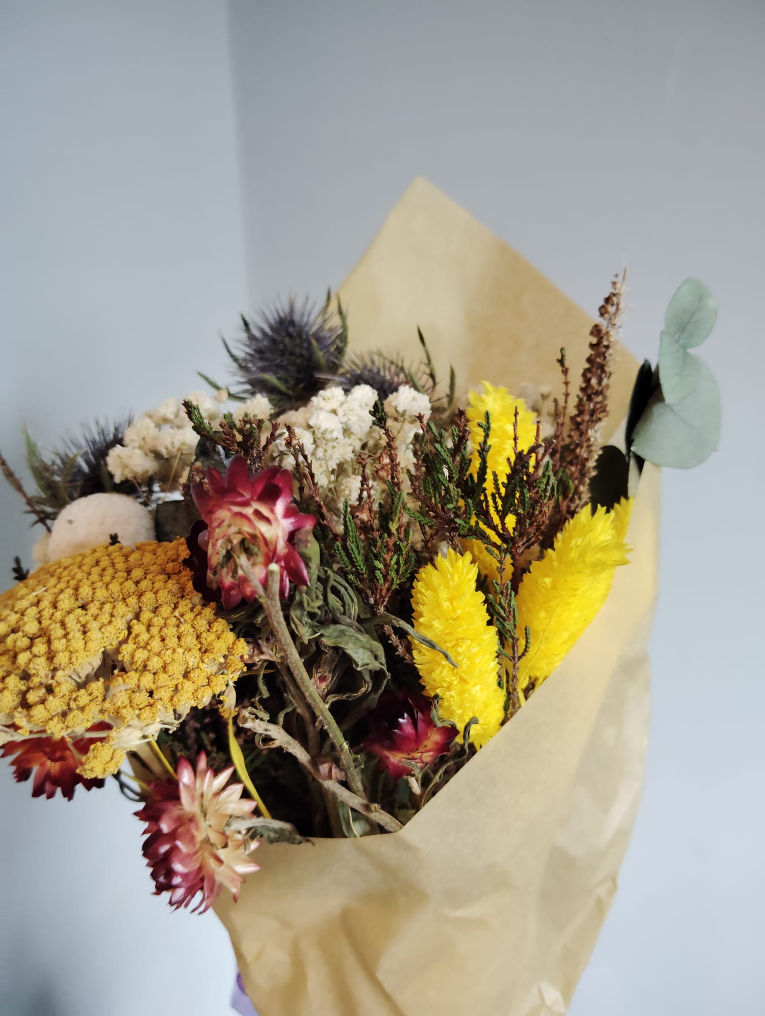 Irish wild meadow inspired dried floral arrangement with yellow everlastings and white baby's breath.