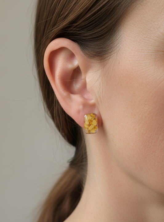 Yellow daisy petal rectangular stud earrings with pressed flowers worn on ear natural light
